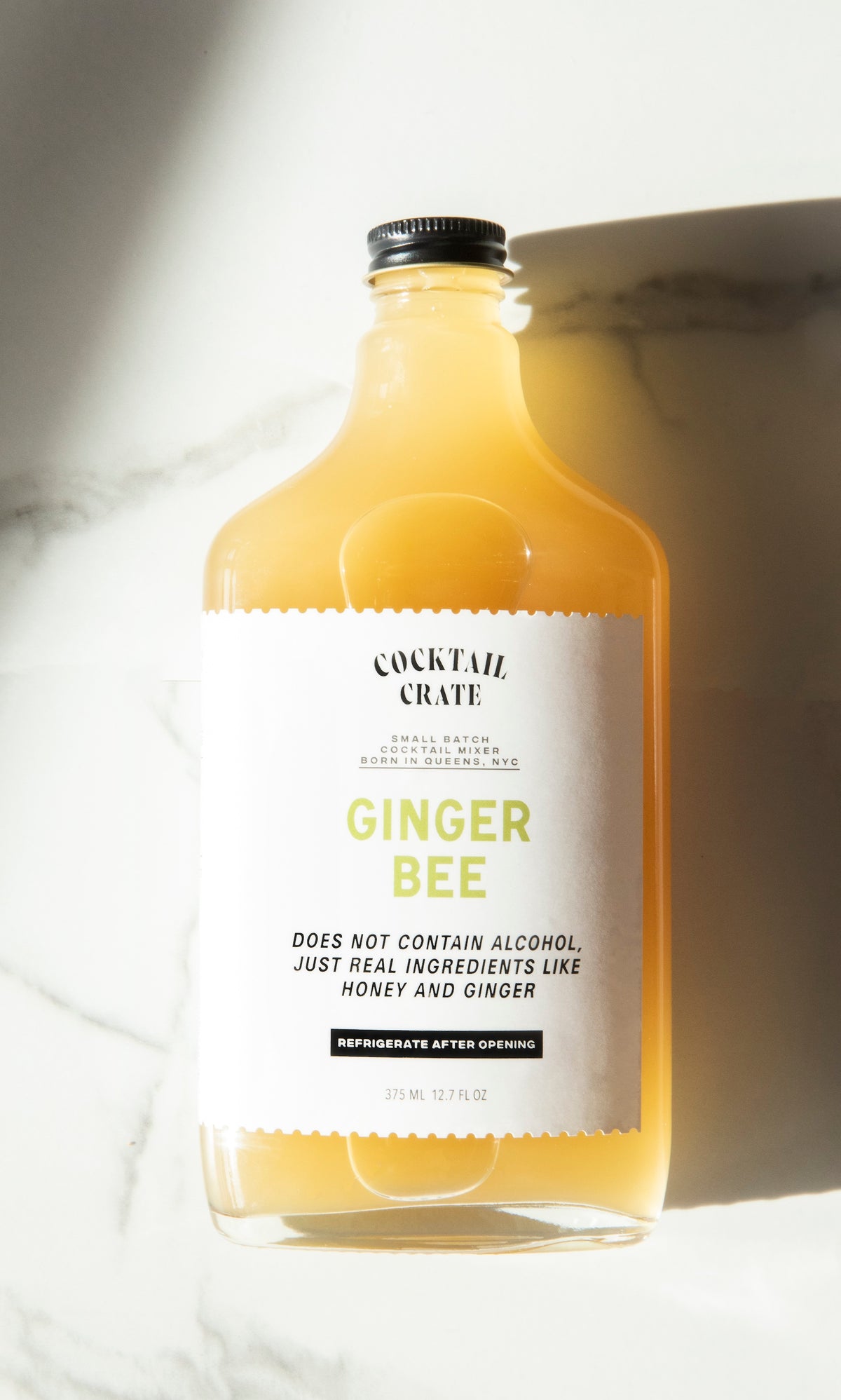 Cocktail Crate Ginger Bee mixer bottle on white marble in sunlight