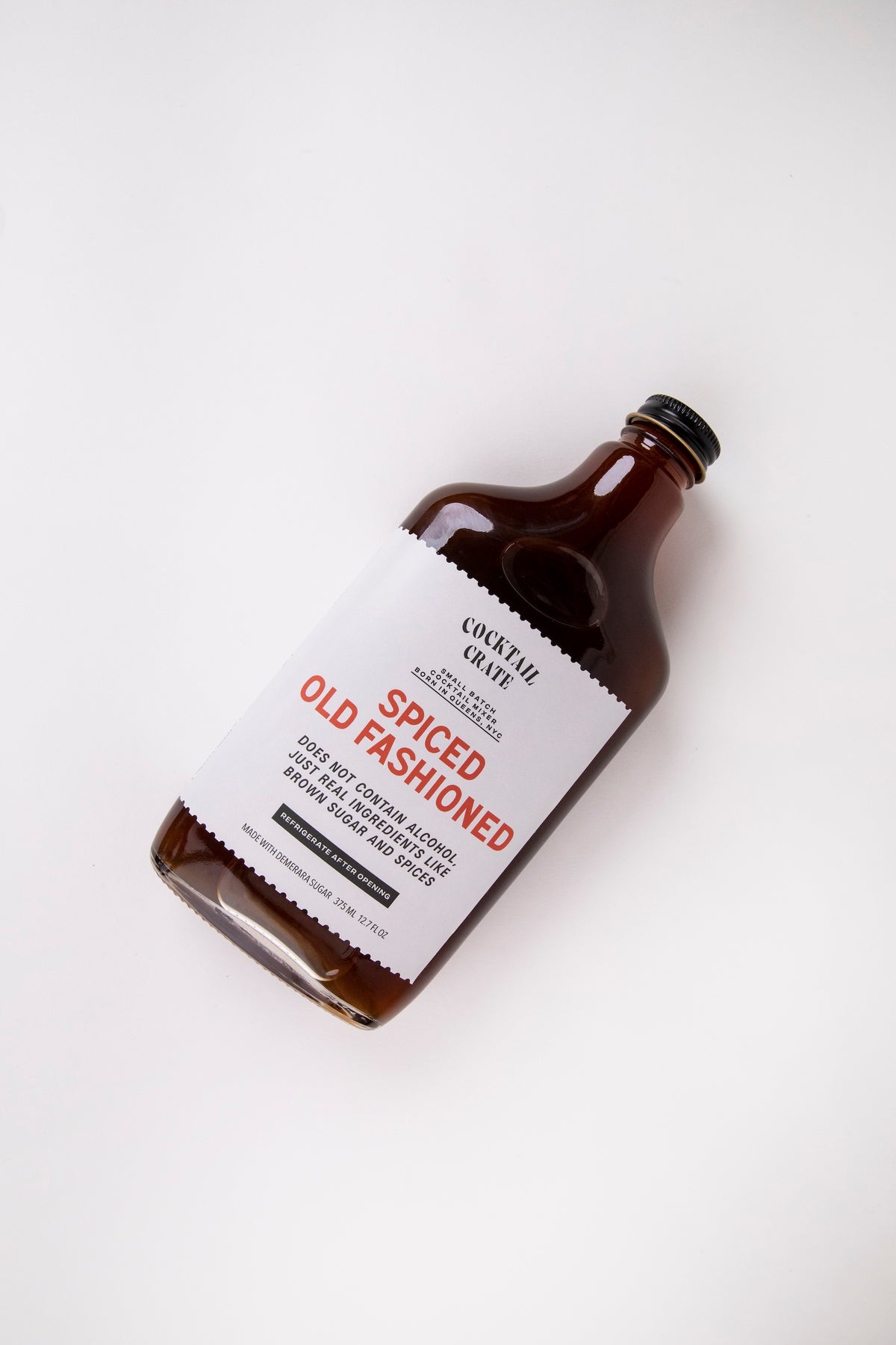 Cocktail Crate Spiced Old Fashioned mixer bottle lying on a white backdrop