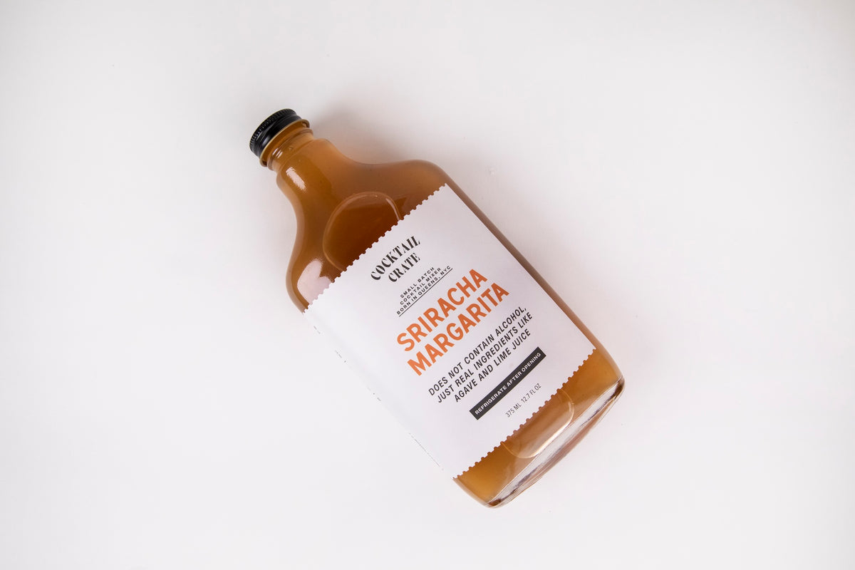Cocktail Crate Sriracha Margarita mixer bottle lying on a white backdrop